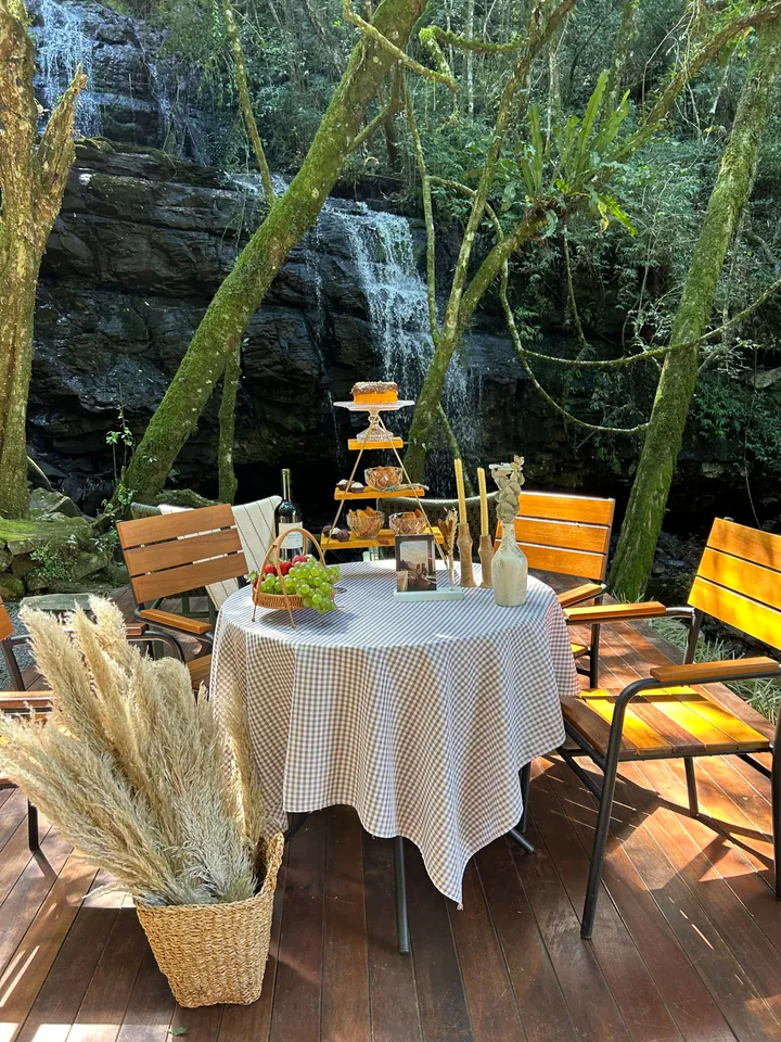 Mesa posta no deck, diante da cascata